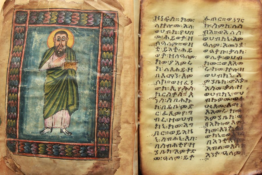 Dvojstrana z evangeliářů kláštera Abba Garima po restaurování: vlevo postava s knihou, vpravo text v geʽez ve dvou sloupcích, slova odděluje znaménko ze dvou teček. Ne všechny listy jsou stejně staré, k souboru patří i evangeliář asi ze 14. století.