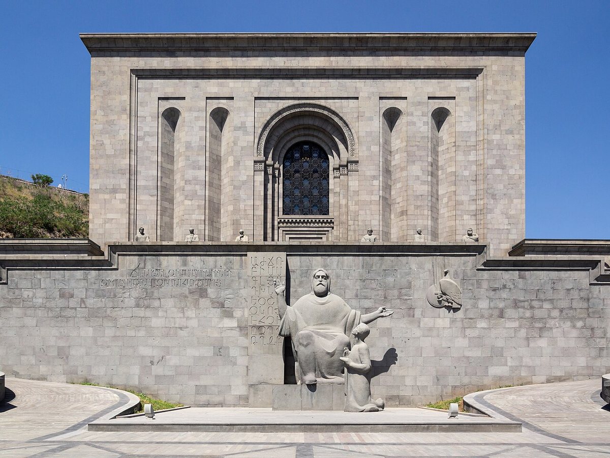 Matenadaran v Jerevanu. Před budovou stojí socha Mesropa Maštoce s jeho žákem Korjunem od Ghukase Čubarjana (1962, v čediči 1967), nad ní sochy šesti středověkých arménských učenců.