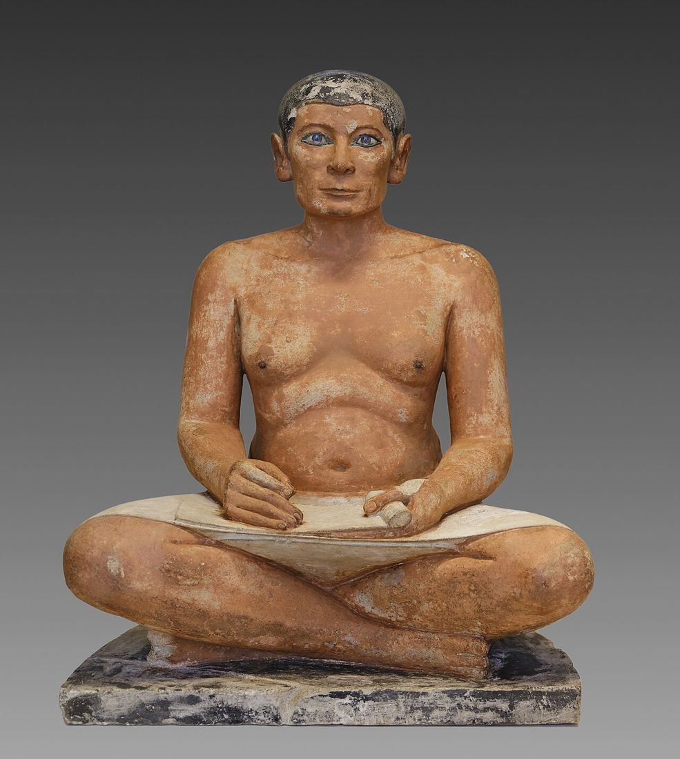 Sedící písař s rozvinutým papyrem na klíně, malovaný vápenec ze Sakkáry, doba Staré říše. Louvre, Paříž.