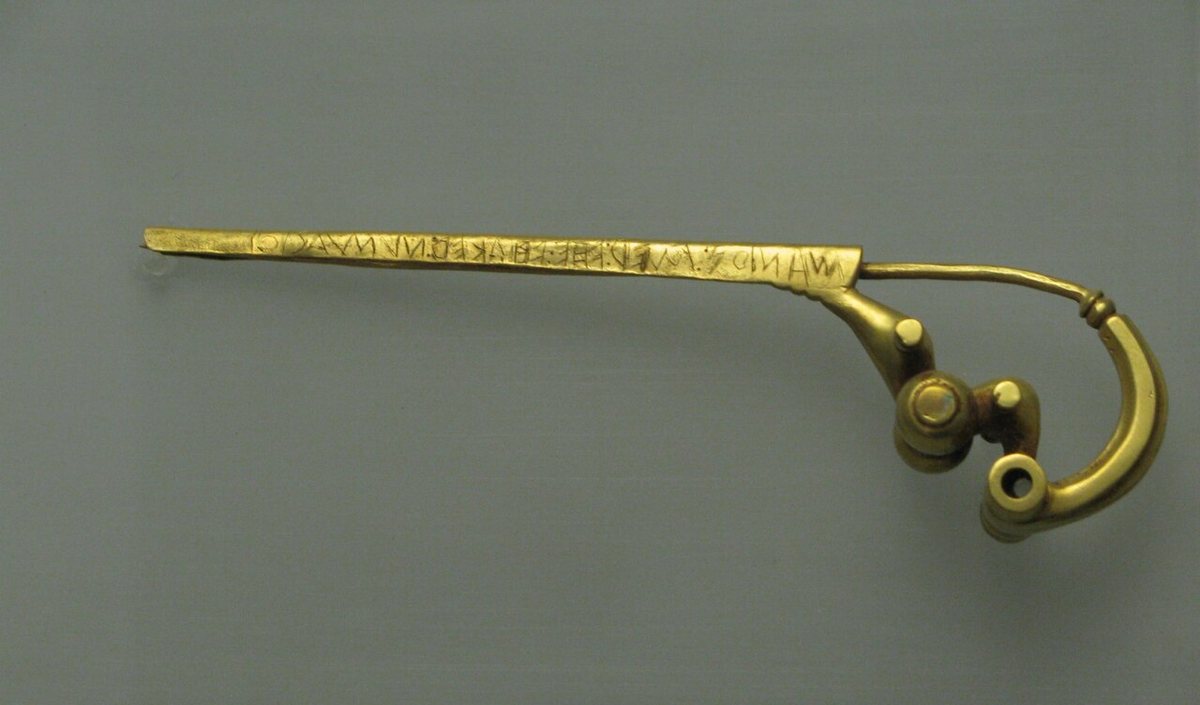 Zlatá spona (fibula) z Praeneste, dnešní Palestriny, s nápisem MANIOS MED FHEFHAKED NVMASIOI, čteným zprava doleva. Pokud je pravá, pochází ze 7. st. př. n. l. Národní prehistorické a etnografické muzeum Luigiho Pigoriniho v Římě.