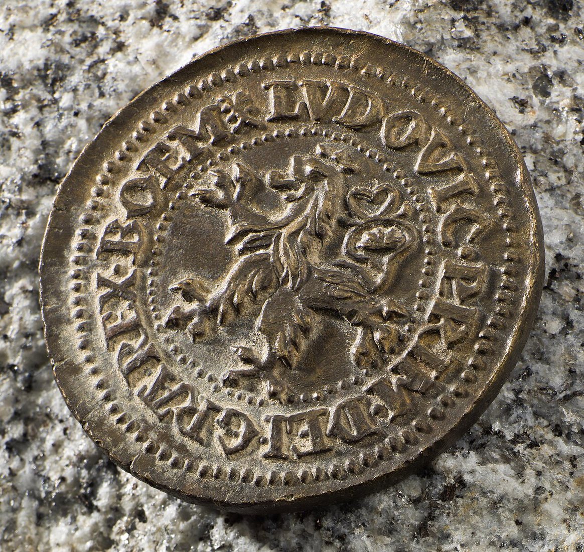 Jáchymovský tolar z roku 1525, strana s českým lvem a jménem krále Ludvíka Jagellonského. Minci našli roku 2000 v Norsku.